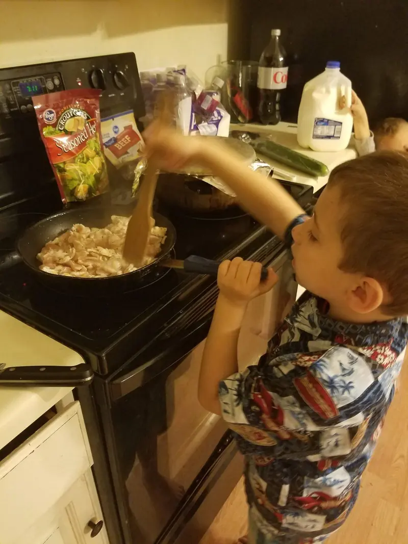 Chef Joe’s son stirring a pot at the stove